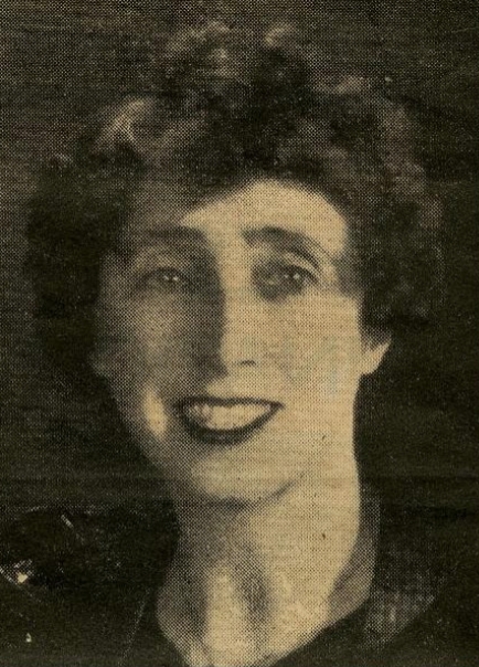 A black and white head 
   shot of Ann, taken from a newspaper cutting. She has dark, curly hair, is beautifully made-up and is smiling.