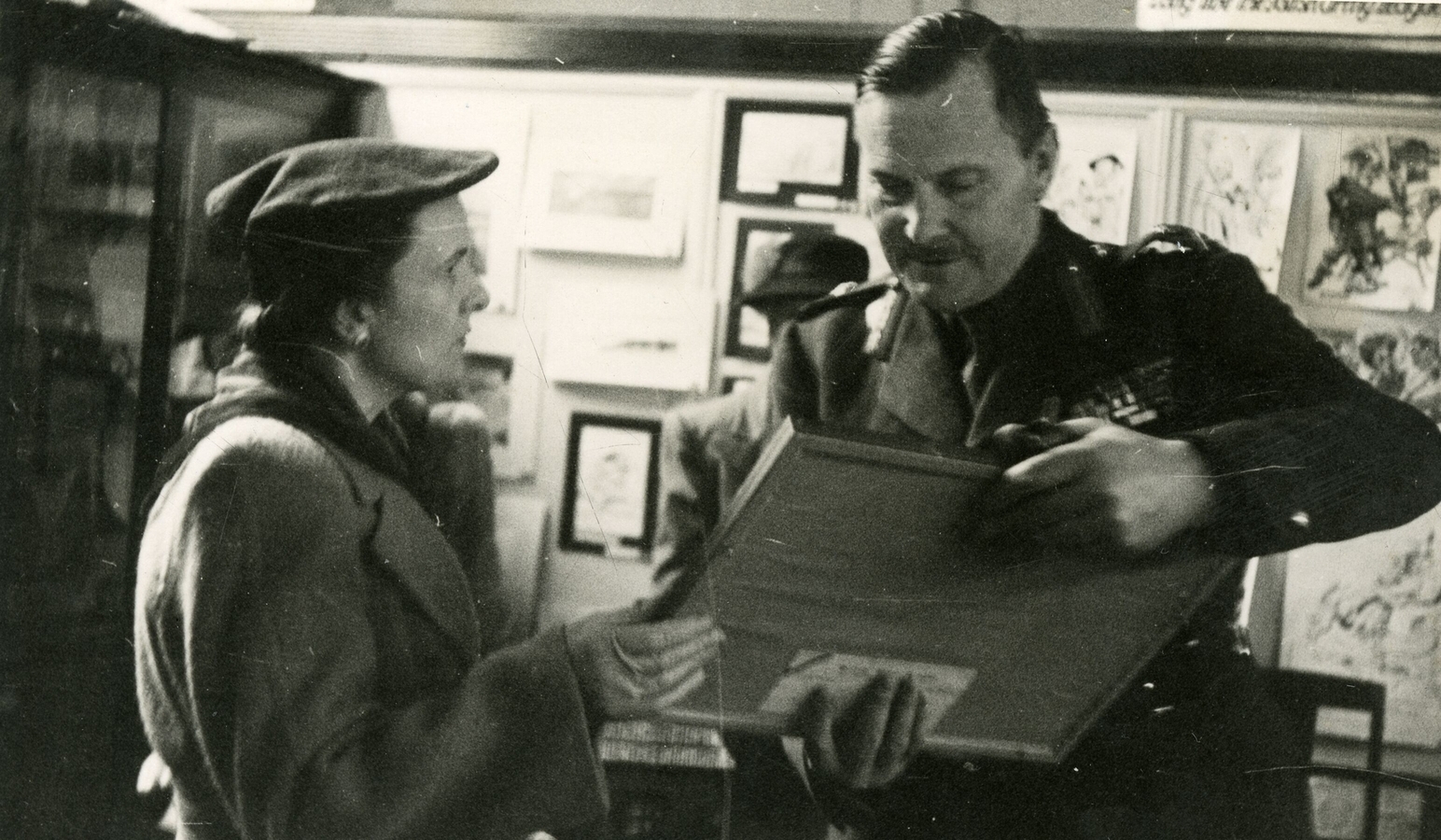 Mrs 
   Jacques, bending over Gen Freyberg, who has papers in his hand, both looking at the papers.