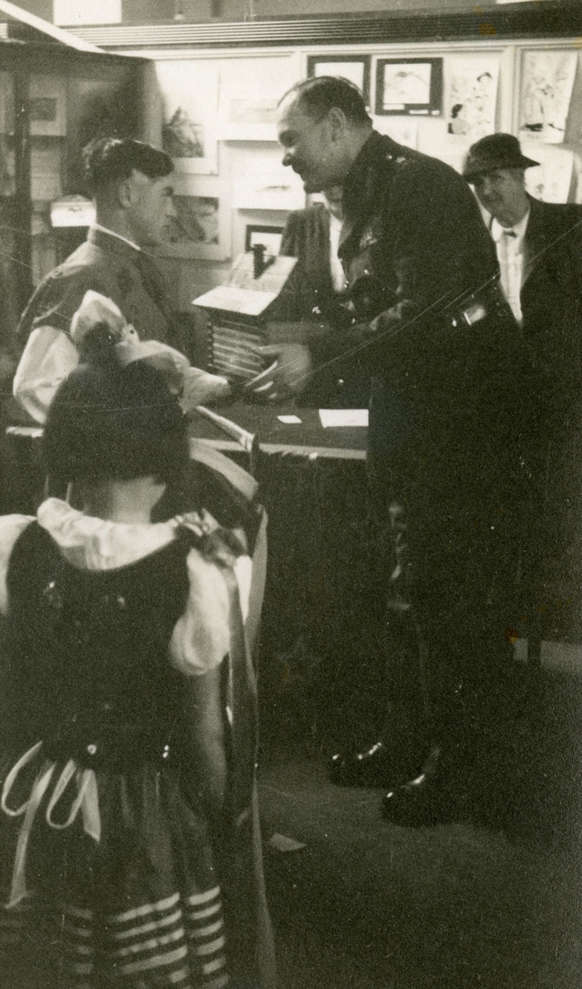 Mrs 
   Jacques, bending over Gen Freyberg, who has papers in his hand, both looking at the papers.
