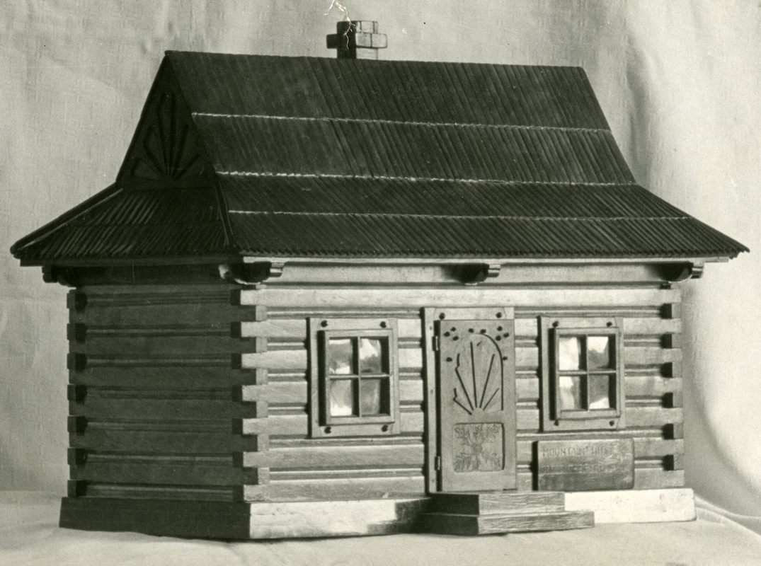 A close-up of the 
   model, showing the intricate tongue-and-groove woodwork, and the tiny stud nails and garved door.