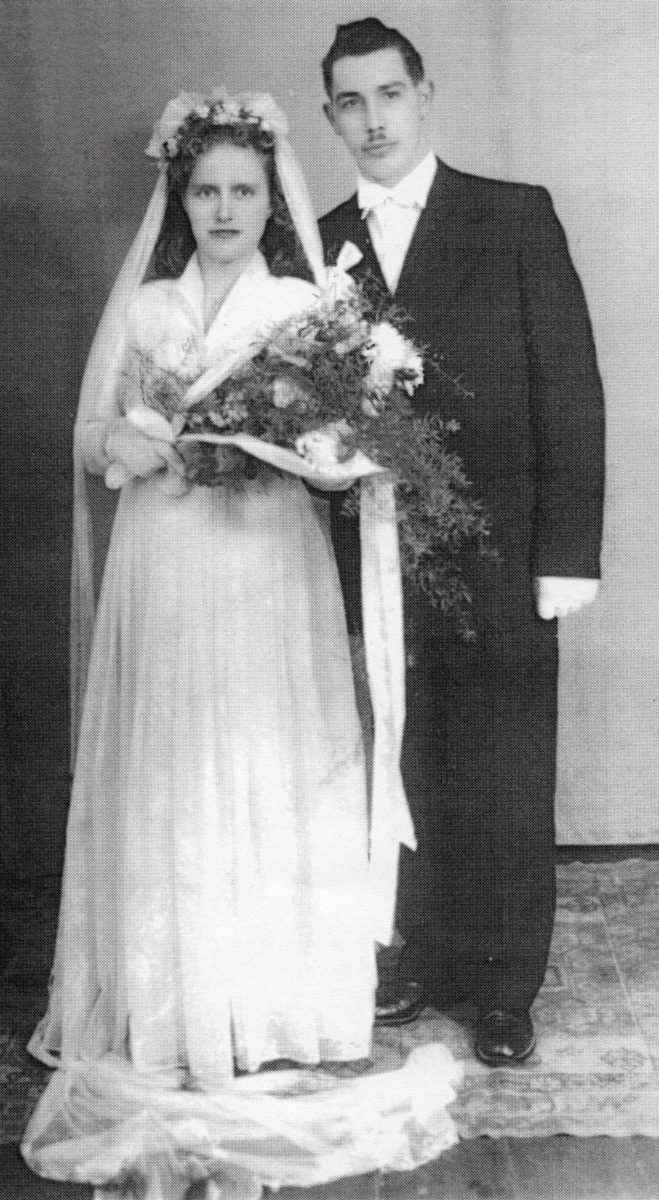 Full-length 
studio shot of Antoni and Halina after their wedding. They seem serious. 
