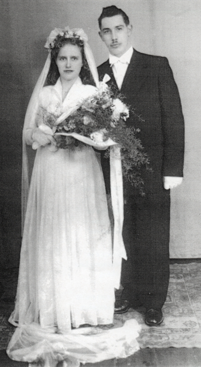 Full-length 
studio shot of Antoni and Halina after their wedding. They seem serious. 