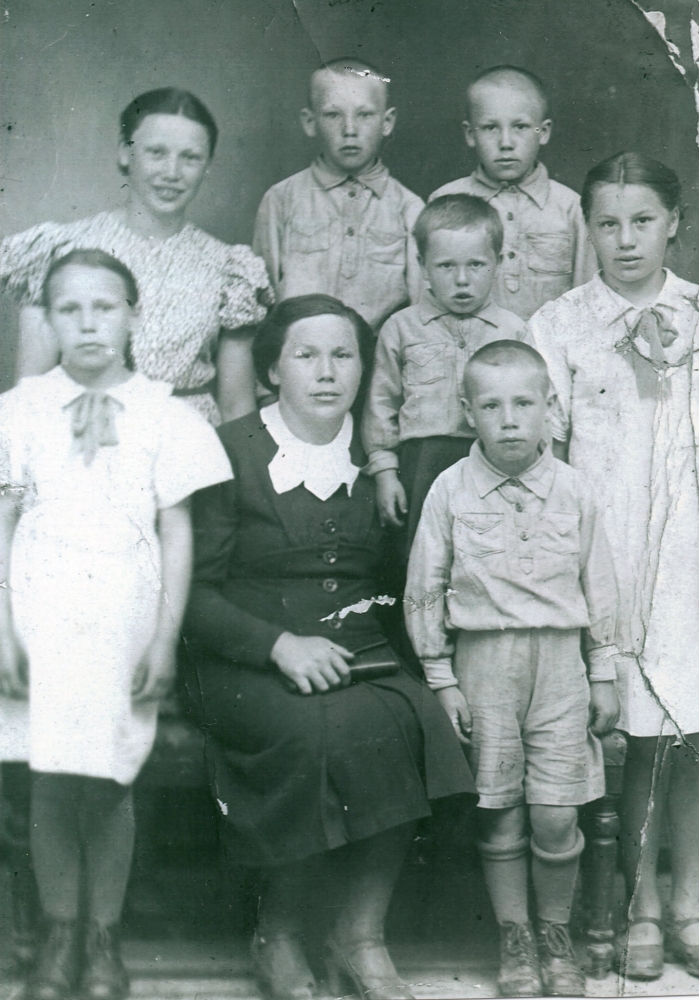 A studio 
photograph of Waleria, sitting with a handbag on her lap and surrounded by her children