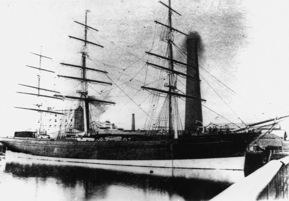 The Fritz Reuter in 
Hamburg harbour. No sails.A Hamburg building is in the background.