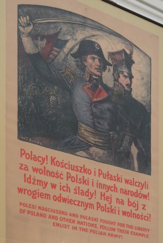 A patriotic poster 
featuring Kosciouszko brandishing a sword spported by a brooding, handsome Pułaski behind him.