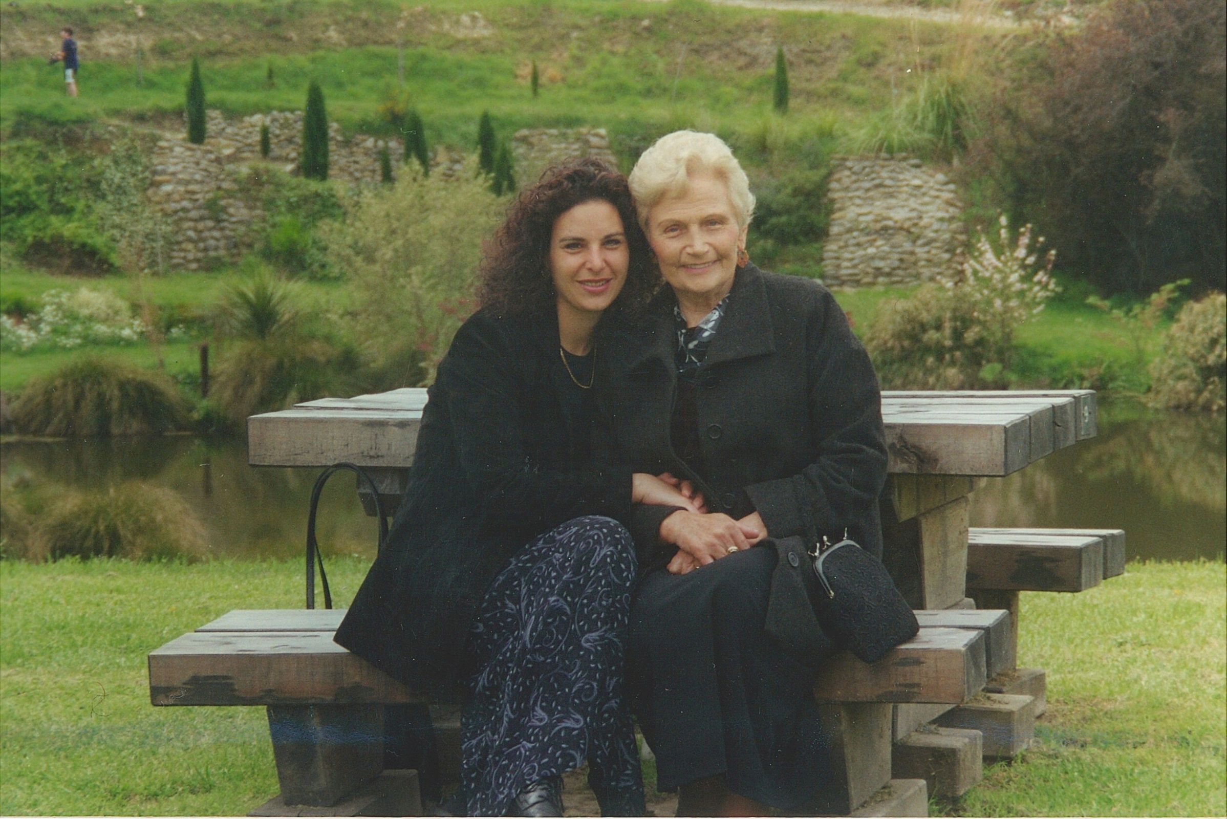 Irena Kuźmiuk sitting with her granddaughter at a picnic table in a Christchurch park.