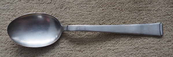 A non-descript spoon, 
plain and a bit bent near the top of the handle.