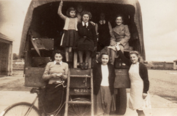 Jadzia standing at 
the back of a truck saying farewell to friends leaving for Poland.