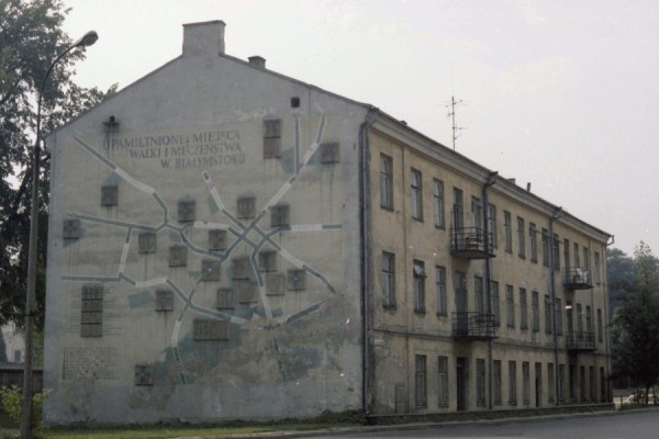 Message, 
map and raised site markers, painted in mostly dull grey shades on the side of an apartment block in Białystok 1980s