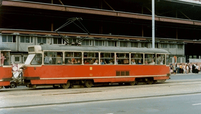 A full Polish 
tram at a station, queue of people outside