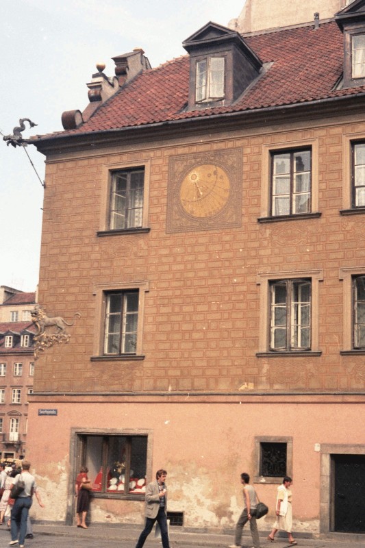 Side of a building 
with a muted celestial graphic, sun and rays