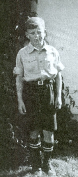 Joe Jagiełło aged 
about 12, standing alone, serious expression