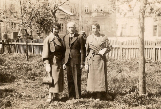 Józef 
Zając with Bronisława and Maria on either side, standing in a garden, fence at background and faint view of nearby houses