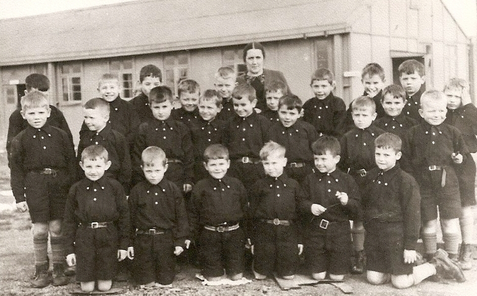 Three 
rows of young boys dressed in dark shirts and shorts with Mrs Petrus at the back.