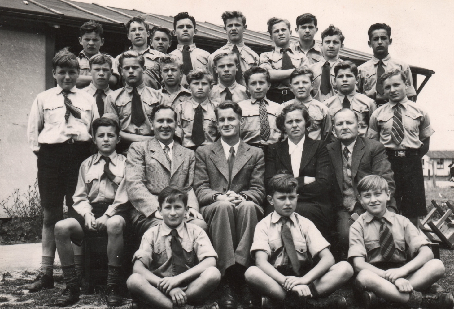 Black and 
white formal photograph of 24 boys with four of their teachers.