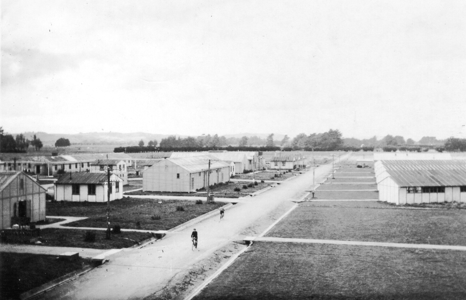 The main street 
of the camp, with two boys on thier bikes. Photograph shows how isolated the camp was.