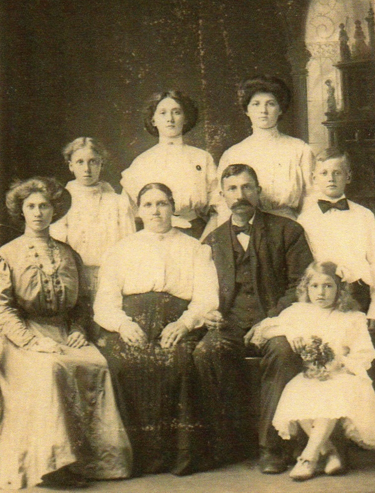 A 
blurry studio photo of Clara, her husband and their five daughters and a son.