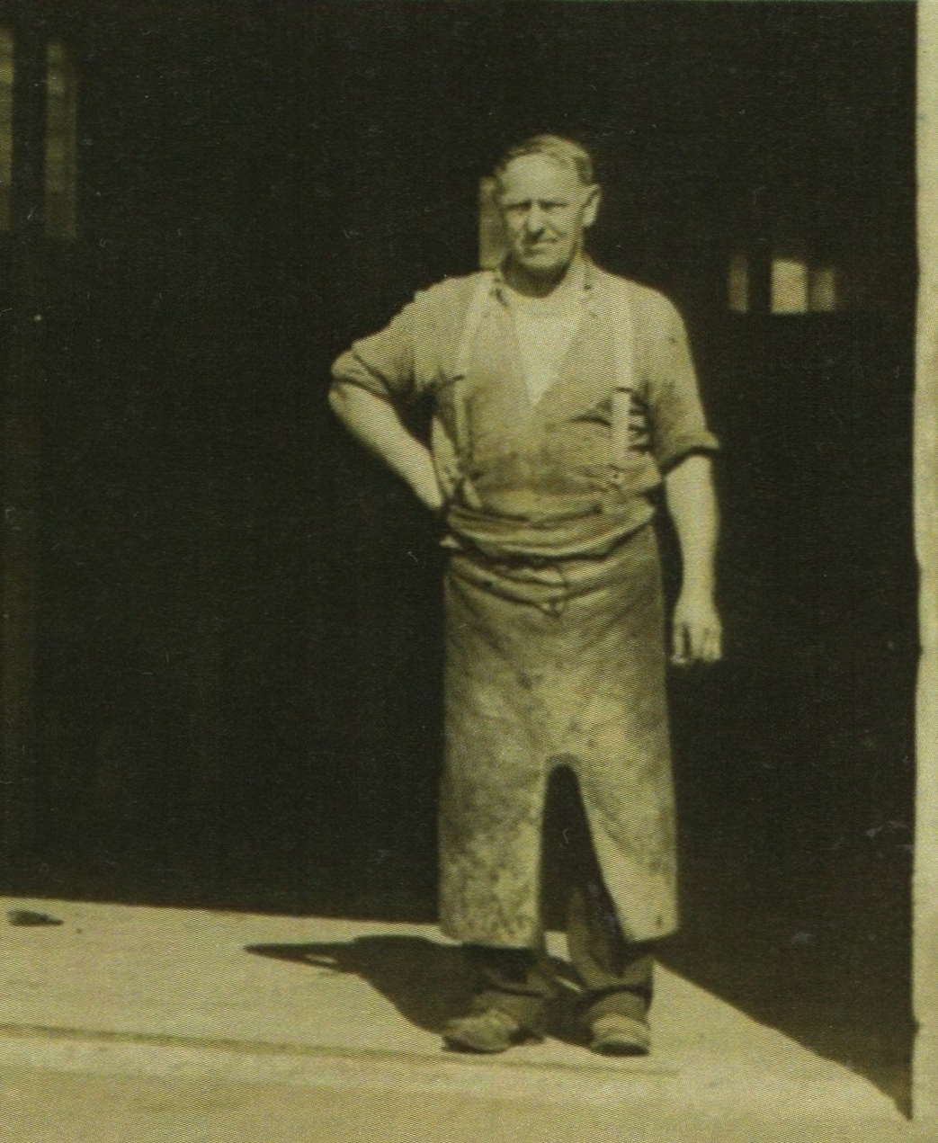 Michael Kowalewski, 
in his blacksmith's apron in the doorway of his blacksmith's forge.