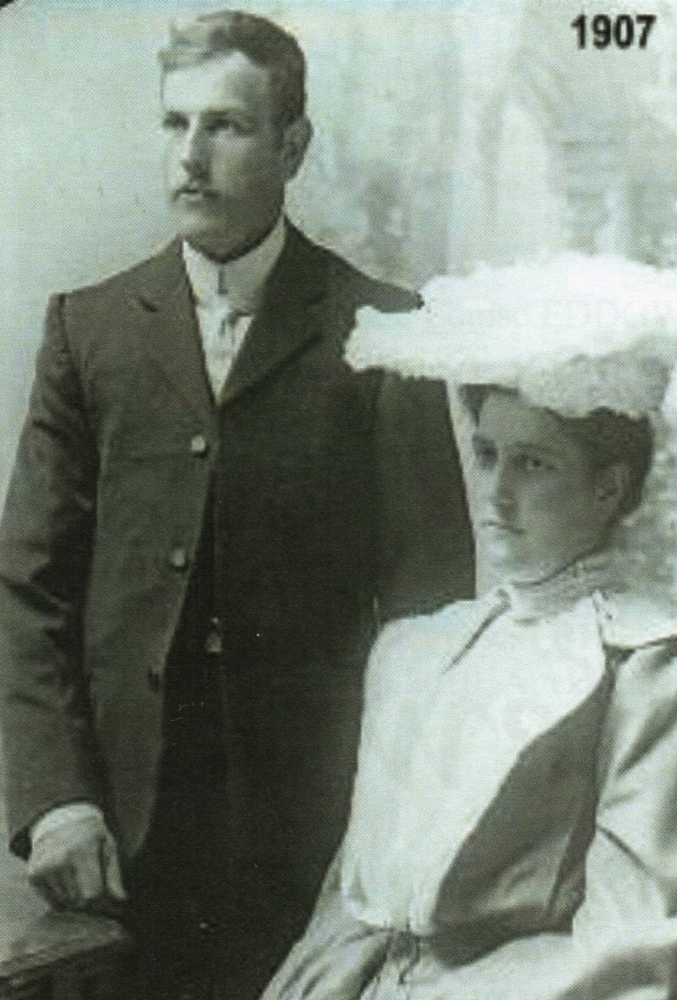 Michael and Clara on their wedding day. Clara is seated and they are both looking to the left.