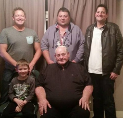 Casual posed photograph 
of three generations of Krefts, grandson and grandfather in front and sons behind