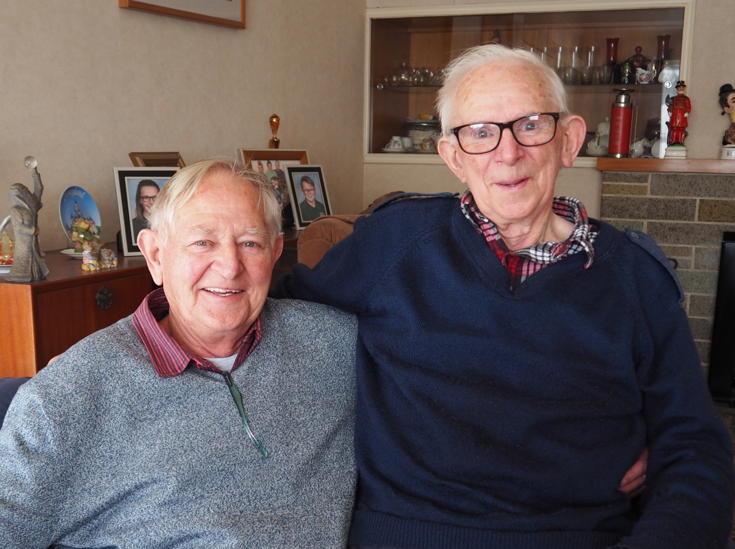 Pat and Joe, 
arms around each other, smiling at the camera. Both in casual sweaters.