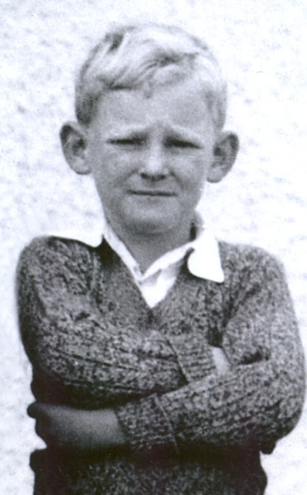 Allan 
Hughes, arms crossed, staring into the camera, as a Standard One pupil in 1941