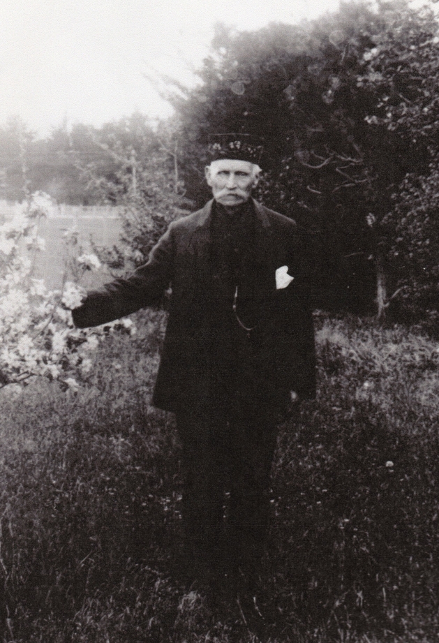 Michael 
Lipinski in a garden, next to a flowering tree