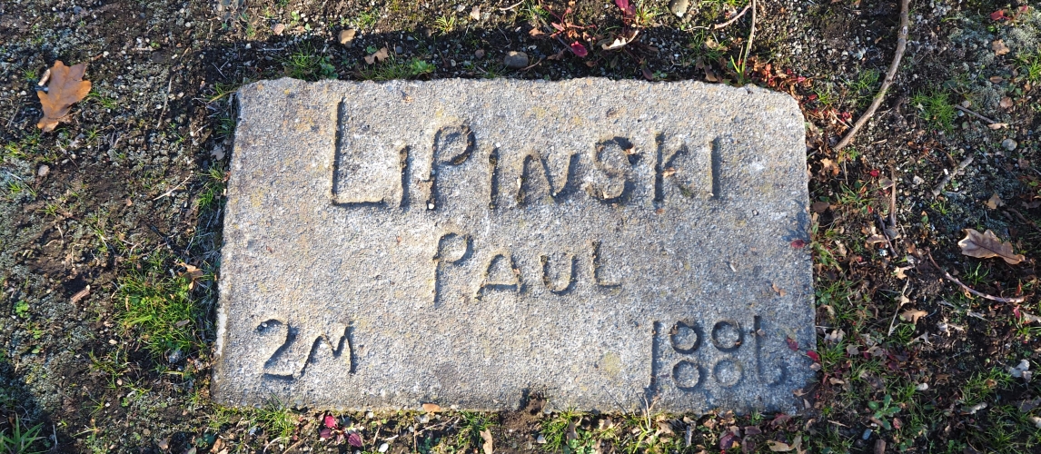 A small concrete 
rectangle in the grass, with Paul Lipinski's name hand-written