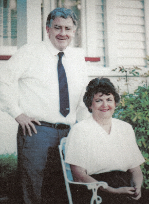 A
casual photograph of Ronald, standing, in shirtsleeves, and Roselyn, sitting