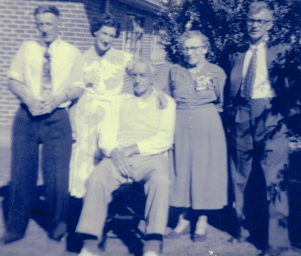 Taken outside a 
house with Bert sitting, behind him are Alfred, Rona, with her arm around her father, Edith and Jack