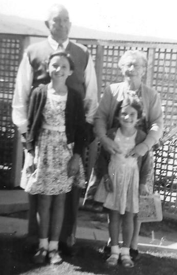 Bert and 
Edith stand behind their young granddaughters Shelley and Kay, all smiling