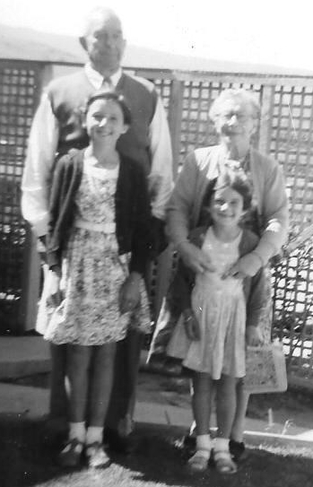 Bert and 
Edith stand behind their young granddaughters Shelley and Kay, all smiling