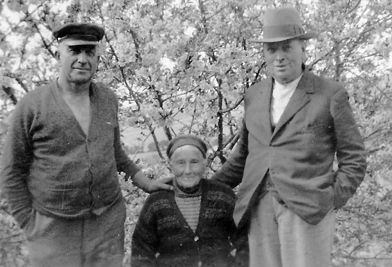 Same setting as 
previous photo, but men are standing and the women in the blossoms missing