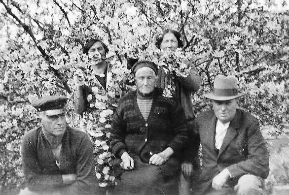 Franciska Orlowski 
seated in front of a flowering tree with Bert on one side, another man on the other and two women hidden in the blossoms.