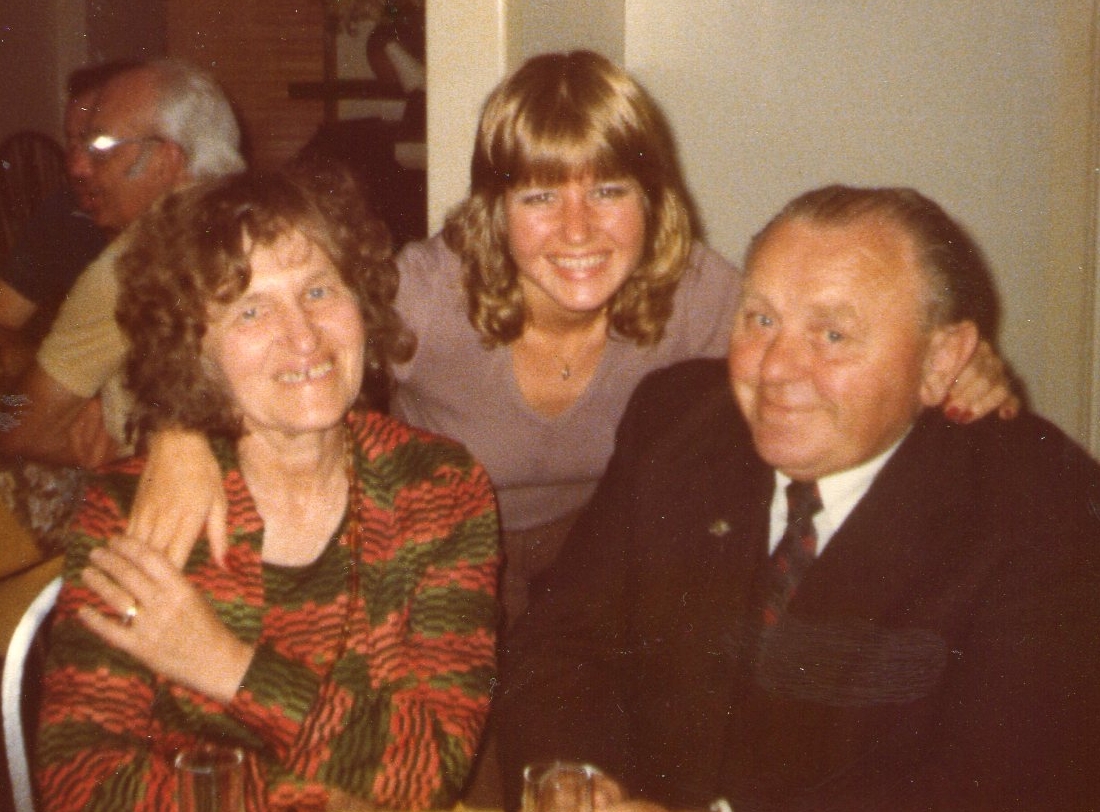 Antos and Janina Sarniak seated, being hugged by their younger daughter Dorotka.