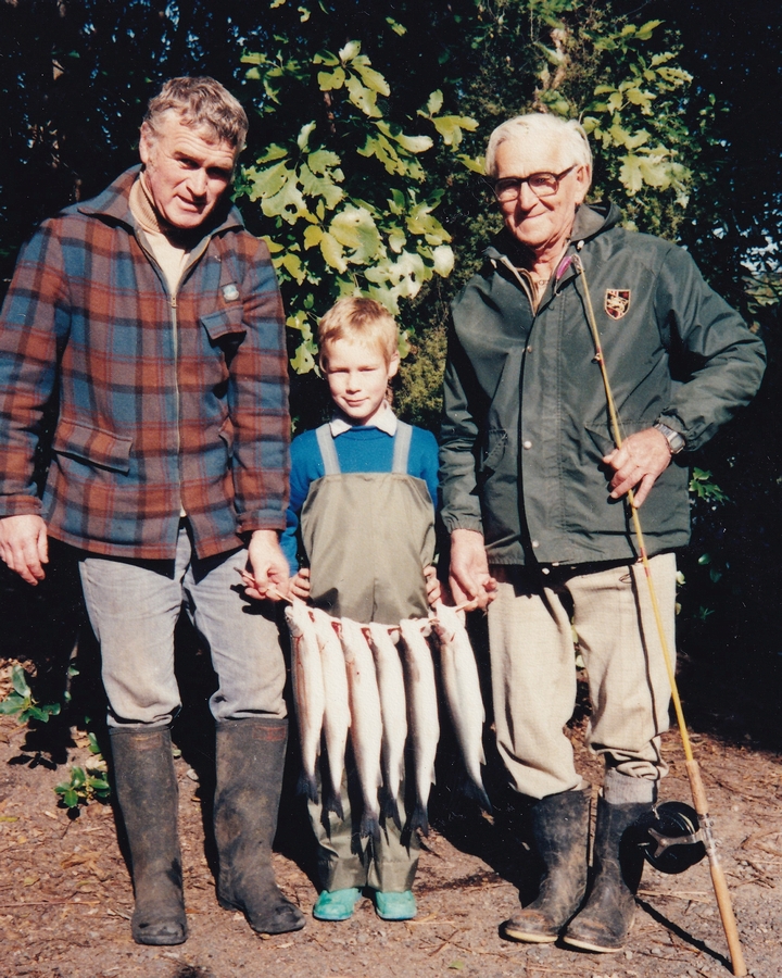 The two men with young Nigel in the middle, and the six trout on a line