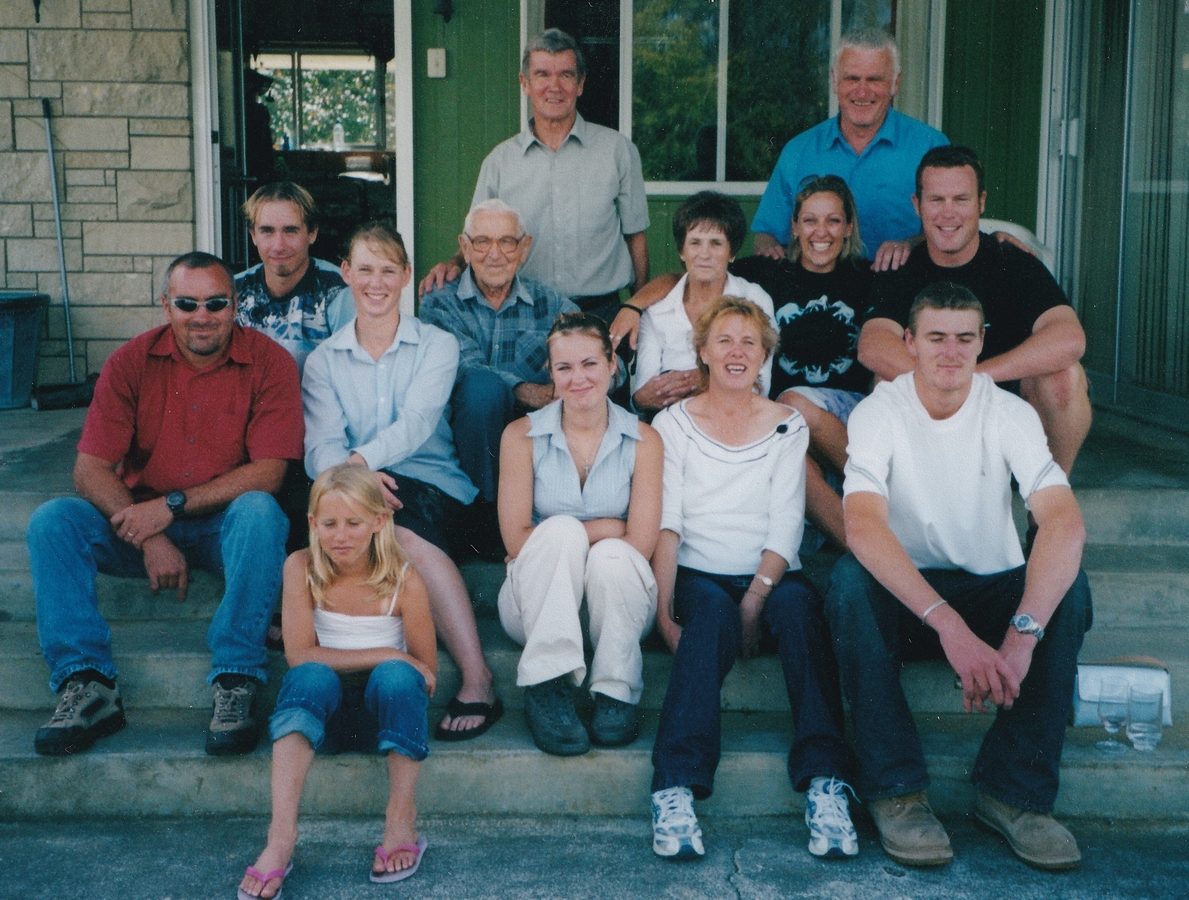 A casual photograph of the family, sitting on steps on a deck