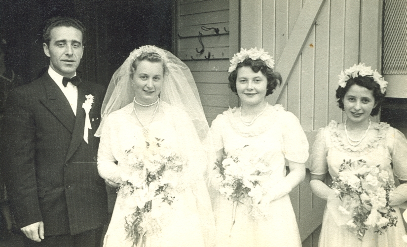 Black and white pic of Władysław and Anna outside a church door, with two bridesmaids to the right.