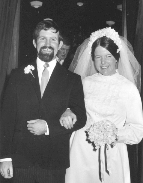 Black and white photograph of the newlyweds leaving a building