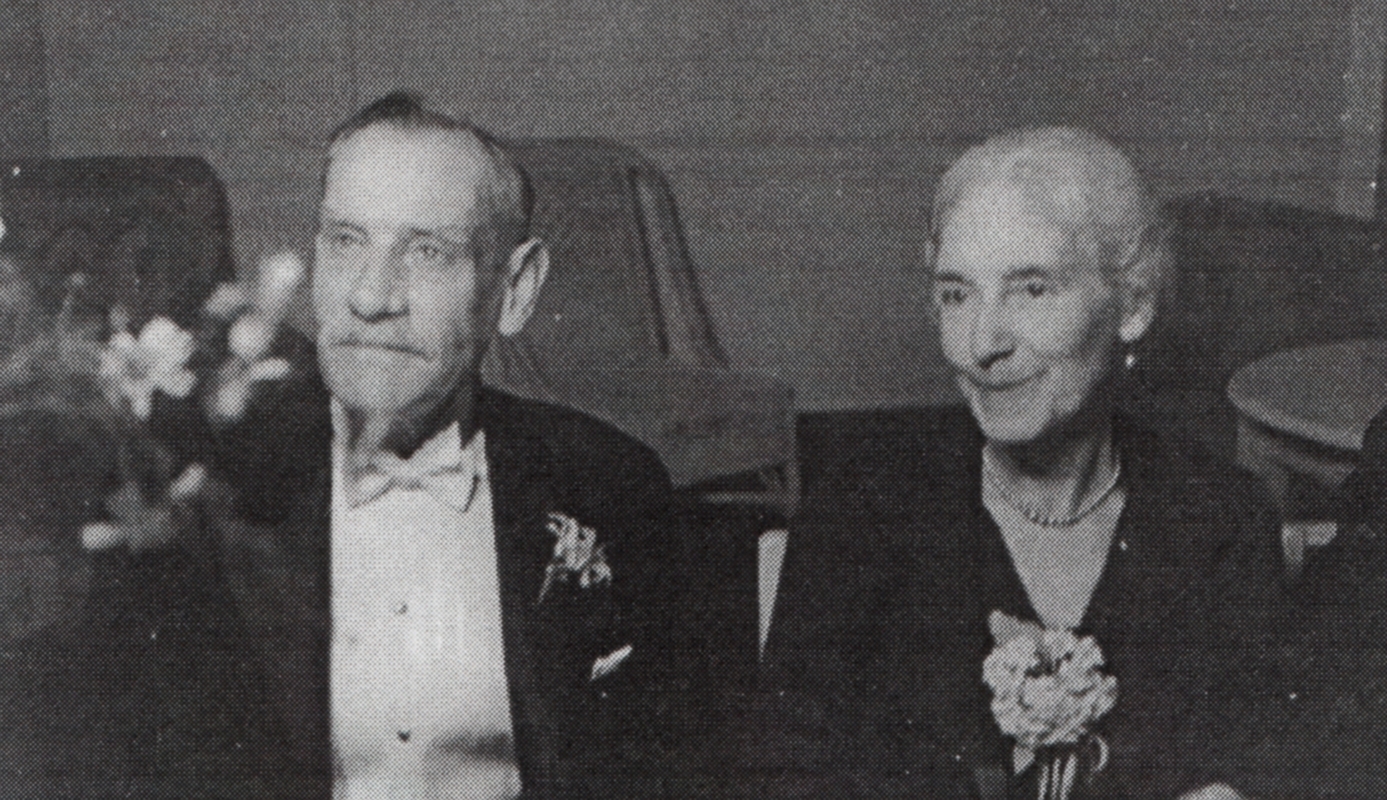 a black and white photograph of two elderly, elegant people in evening wear