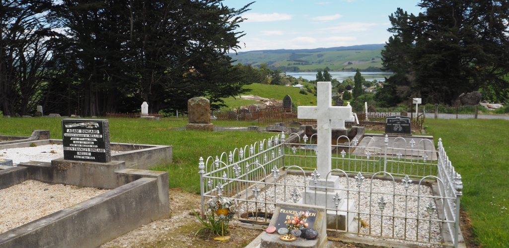 View of some of the headstones at the Waihola cemetery, looking towards the lake.