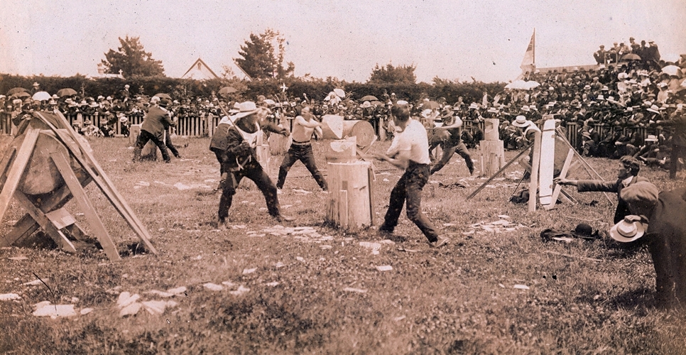 An active pic of 
competitors in the final stages of a competition, with crowds and judges on the grass.