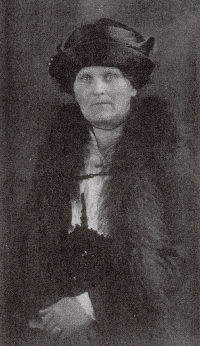 A formal studio 
photograph of an older Mary. She is wearing a fox-fur over her jacket and a complicated silk hat, and looks serious.