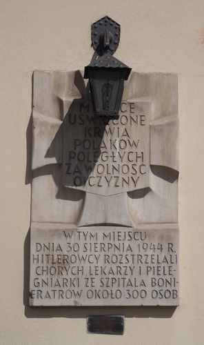 A 
cement plaque, the same beige colour as the building wall, with a lantern above.