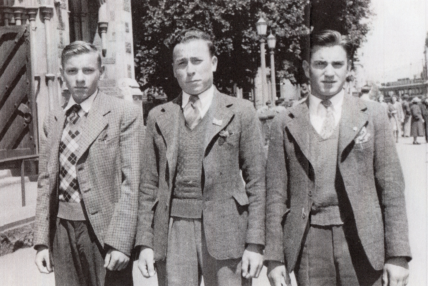 Three smartly-dressed young 
men outside what looks like a church.